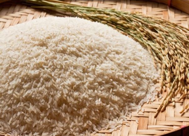 Uncooked grains of white rice on a wicker tray.